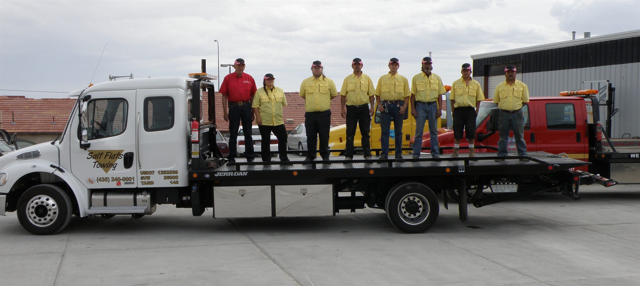 Salt Flats Towing crew standing on a flatbed tow truck